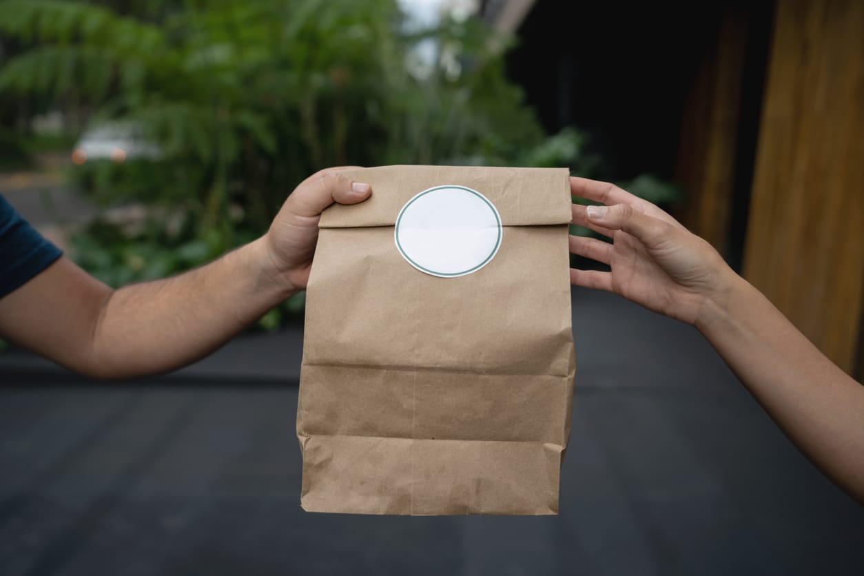 Close-up on a woman delivering a food order to a customer â lifestyle concepts