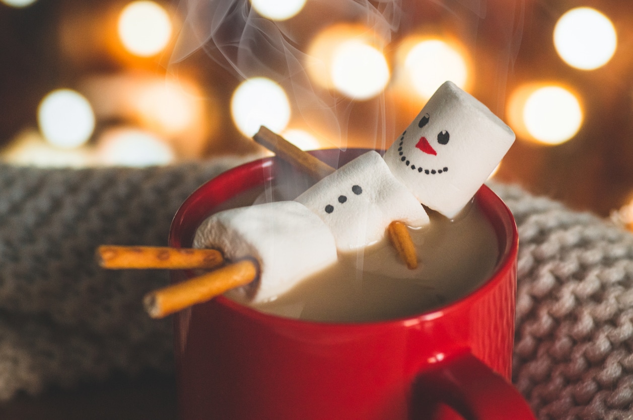 Red mug with hot chocolate with melted marshmallow snowman
