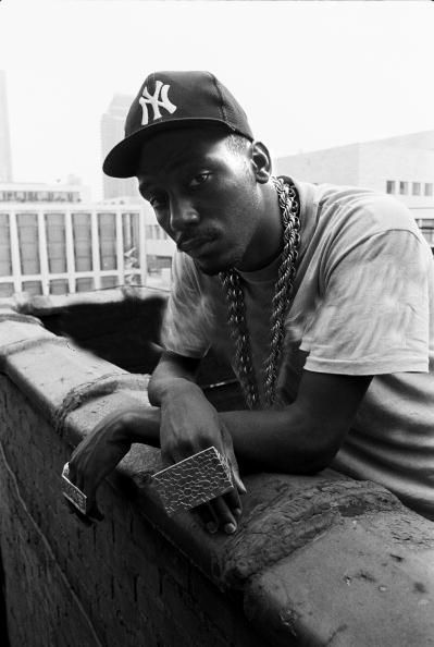 Big Daddy Kane wearing a white shirt and gold chains