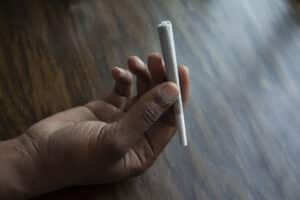 Hand holding Cannabis pre-roll at dispensary